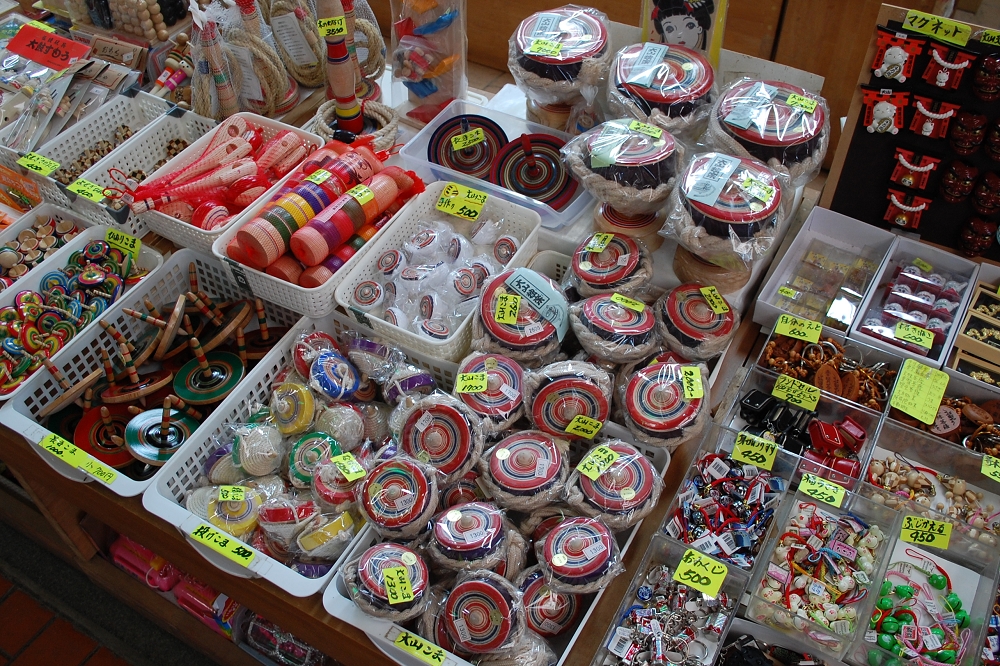 参道のお土産店では、地元の特産品としてこまや木工製品が売られている